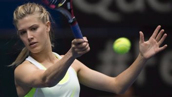 Eugenie Bouchard on Thursday said she was working with Jimmy Connors ahead of the U.S. Open in New York, but has no long-term plans to retain him as her coach. We see Genie dressed in a white tennis dress hitting a forehand. Her blond hair is in a pony-tail as the ball leaves her racquet close to her open left hand that she is using for balance. She has a look of intense concentration on her face.