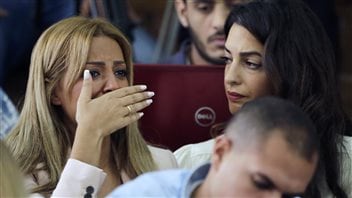 In this Aug. 29, 2015 file photo, the wife of Mohammed Fahmy bursts into tears upon hearing the verdict against her husband. Lawyer Amal Clooney looks on.