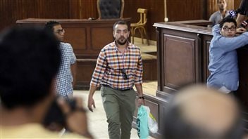 Egyptian journalist Baher Mohammed carried a bag of clothes in the Cairo courtroom prior to his conviction and imprisonment.