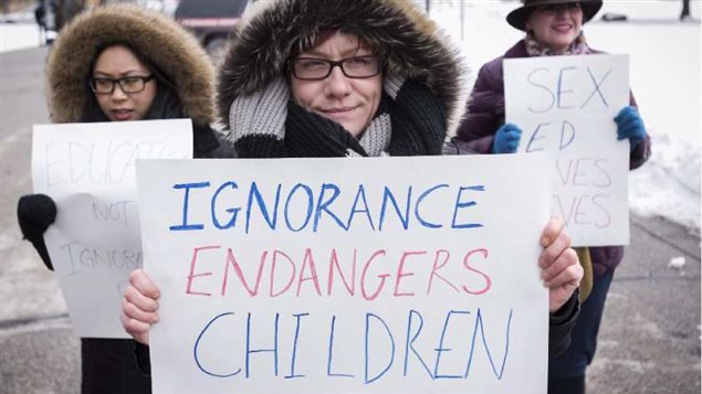Pro-sex education demonstrators hold signs in opposition to a protest opposing Ontario's new sex education curriculum in front of Queen's Park in Toronto on Tuesday, February 24, 2015. Now a sex education pilot project is being introduced in Quebec schools.