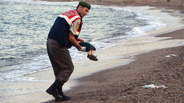شرطي تركي يحمل جثة الطفل السوري الذي قضى غرقا 