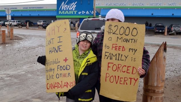 Dos jóvenes expresan su desacuerdo con la realidad de la crisis alimentaria por los altos precios de la comida en Nunavut
