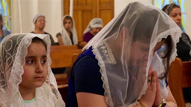 مسيحيات يصلين في إحدى كنائس بغداد (أرشيف)