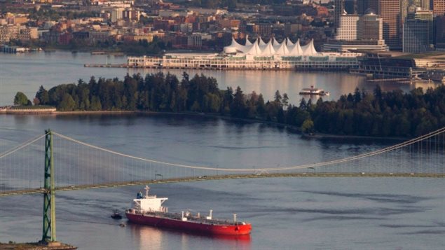 An oil tanker, guided by tugboats, goes under the Lions Gate Bridge at the mouth of Vancouver Harbour.