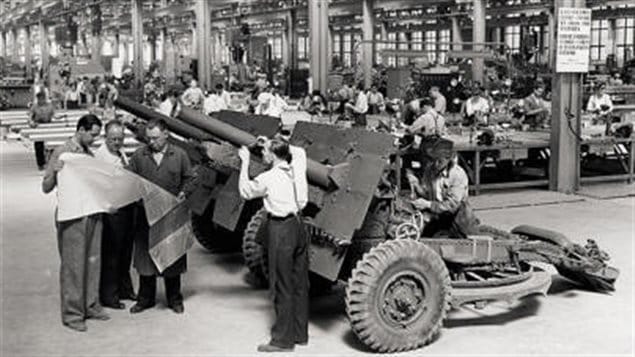 Workmen and engineers at the Sorel Industries Ltd look over blueprints of the 25-pounder field artillery piece. The giant SIL operation prouduced thousands of field artillery pieces, and naval and anti-aircraft guns and supplied barrels for the Sexton self-propelled guns prouced in Montreal at the two tank factories.