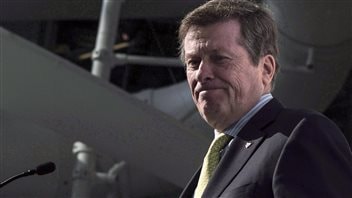 Toronto Mayor John Tory said Toronto just wasn't ready to host the 2024 Summer Games. We see Tory in front of a microphone. He has short brown hair and a look resembling chagrin on his down-turned lips. He wears a classy, dark suit, blue dress shirt and yellow tie. He appears quite fit and sports a ruddy complexion.