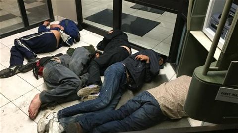 Des sans-abri trouvent refuge dans l'entrée d'une banque à Saskatoon. 