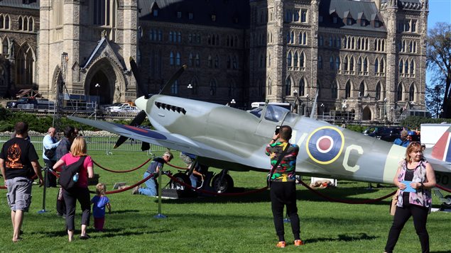 People take photographs of a vintage World War II Supermarine Spitfire fighter aircraft on Parliament Hill during the 75th anniversary of the Battle of Britain ceremony in Ottawa, Sunday Sept. 20, 2015. 