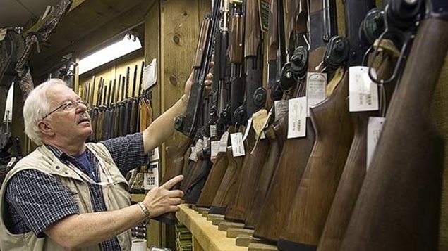 A man replaces a shotgun in the rack in a downtown Montreal outdoor store. When not in use, all guns in Canada must have trigger locks, and there are clear laws about safe storage which apply to legal gun owners.
