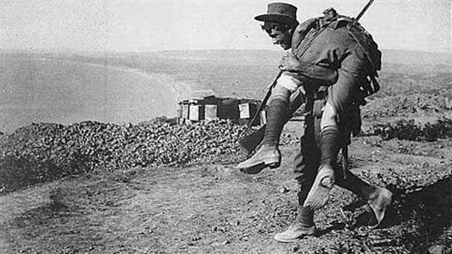 ANZAC solider carrying a wounded comrade back to the line with Anzac cove in the background