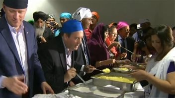 Conservative candidate Jason Kenney (blue hat) and party leader Stephen Harper (left) hope to win several immigrant ridings.