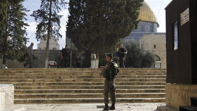 شرطي إسرائيلي يقوم بالحراسة في القدس الشرقية المحتلة ويبدو في عمق الصورة مسجد قبة الصخرة (أرشيف).