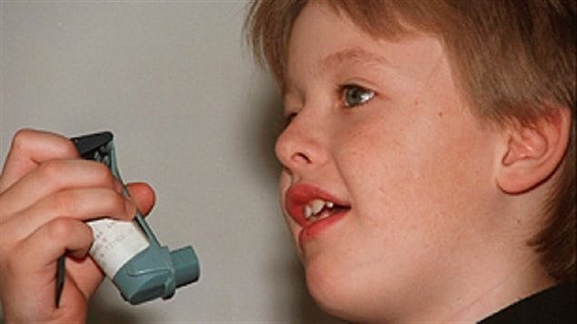 A new Canadian study says asthma sufferers should get out of their chairs and off of their couches. We see a lovely young blond-haired boy of about six or seven (I would guess) about the place a white and grey inhaler to his mouth.