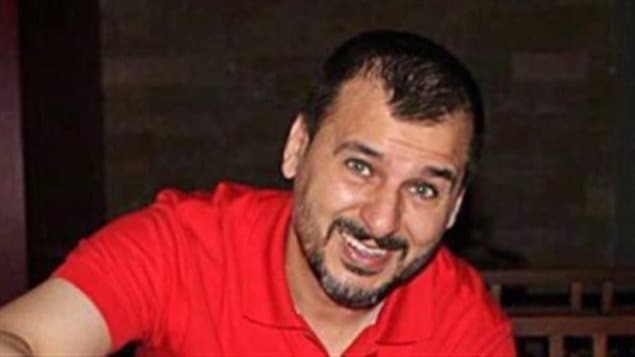 Canadian Salim Alaradi, seen in a 2013 family handout photo, has been jailed in the United Arab Emirates for over a year without an explanation. We see a handsome, dark-haired man, dressed in a red tee-shirt. He has a bit a beard and his hair is receding on the sides. He has bright eyes and full smile.