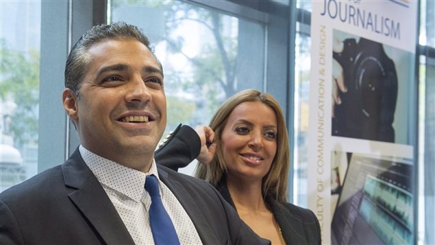 Mohamed Fahmy and his wife, Marwa Omara, are back in Canada following their long nightmare in Egypt. We see Fahmy on the right dressed in a classy, grey suit and blue tie, smiling in the left of the picture. His wife, to his left, has her right hand to her ear and is also smiling. Both appear ready for the rest of their life.