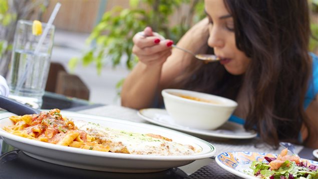 Une femme mange une soupe à l'extérieur. Une femme mange une soupe à l'extérieur.