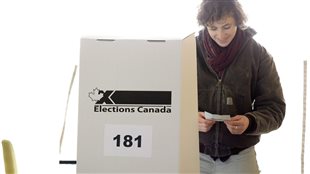 Une femme de la région de Toronto examine son bulletin de vote en 2015.