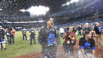 Wednesday's starting pitcher, Marcus Stroman, was--to say the least joyful--following the game. Stroman has his eyes closed and mouth wide open as champagne spray fills the air. In the background are security guards and cameramen.