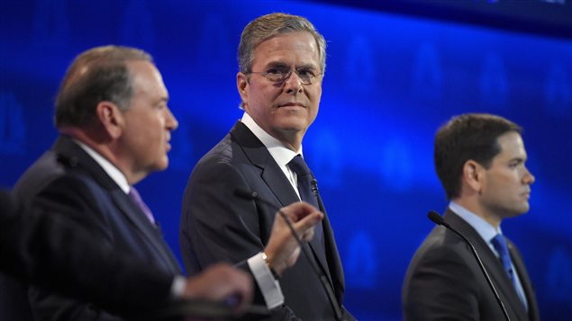 Jeb Bush mira a su rival Mike Huckabee durante el debate de anoche. En el fondo de la foto el senador Marco Rubio.