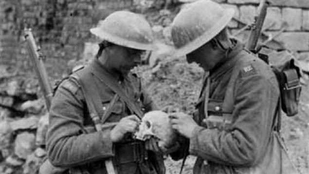 Canadian soldiers examine a skull: With death a constant presence, soldiers coped in various ways, and belief in premonition and spirits was widespread