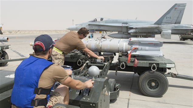 Royal Canadian Air Force Air Weapon Systems Technicians, deployed as part of Air Task Force – Iraq, prepare munitions for loading to a CF-188 Hornet, at the Camp Patrice Vincent flight line in Kuwait, during Operation IMPACT on August 1, 2015. (Photo: OP IMPACT, DND)