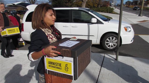 La conjointe de Raif Badawi, Ensaf Haidar, transporte une des boîtes contenant les cartes de souhaits. 