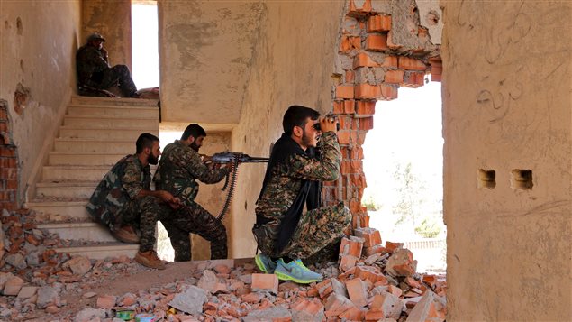  Kurdish People's Protection Units (YPG) fighters take up positions inside a damaged building in Ghwayran neighborhood in Hasaka city, Syria July 22, 2015.