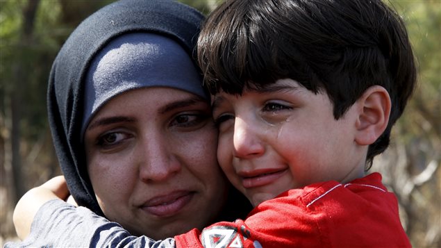  A Syrian refugee woman embraces her crying son moments after arriving aboard an overcrowded dinghy on the Greek island of Lesbos, after crossing a part of the Aegean Sea from the Turkish coast to Lesbos, September 26, 2015.