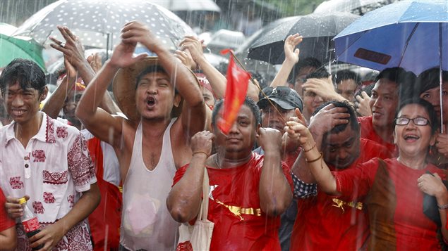 Partidarios de Aung San Suu Ky, reunidos bajo la lluvia frente la sede del LND.