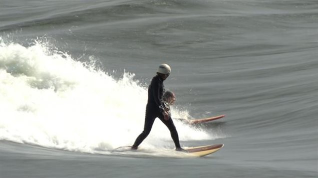 Surfing enthusiasts enjoy wave surfing in the St. Lawrence River near Montreal.