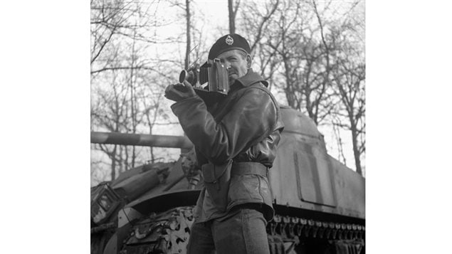 Lieutenant H. Gordon Aikman of the Canadian Army Film and Photo Unit, holding an Anniversary Speed Graphic camera. Vught, Netherlands, February 1, 1945