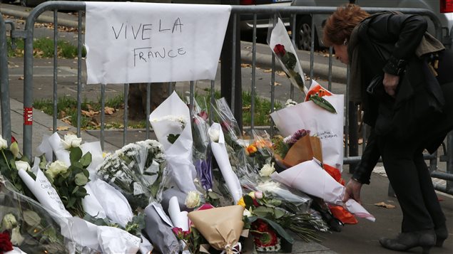 Une femme déposes fleurs devant le Bataclan, où plus d'une centaine de personnes ont été tuées. Une femme déposes fleurs devant le Bataclan, où plus d'une centaine de personnes ont été tuées.