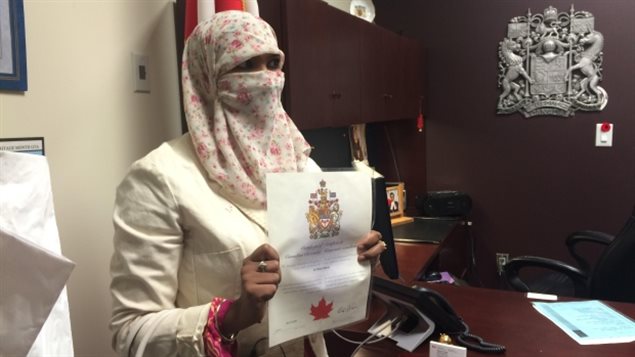 Zunera Ishaq holds her citizenship certificate after swearing the oath on Friday afternoon. She started wearing a niqab at age 15, against her family's wishes. (Sylvia Thomson/CBC)
