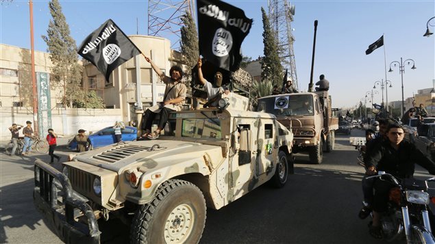 ISIS militants parade captured American equipment.