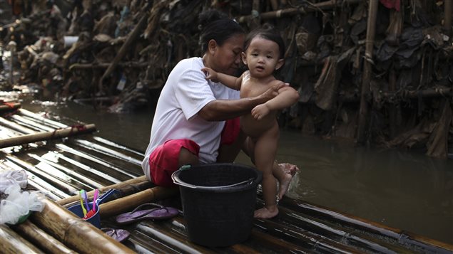  A mother bathes her child near a stack of rubbish in Ciliwung river in the Indonesian capital of Jakarta May 28, 2009.