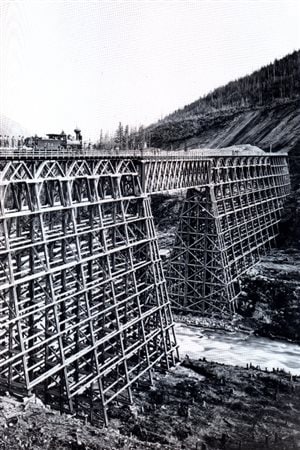 A complicated huge wooden trestle over a gorge, just one example of many extremely difficult and often hazardous challenges to compelte the railwa
