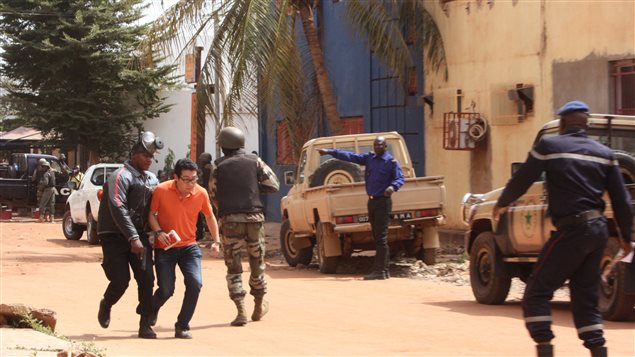 Un militaire malien évacue un otage à l'extérieur de l'hôtel, à Bamako.