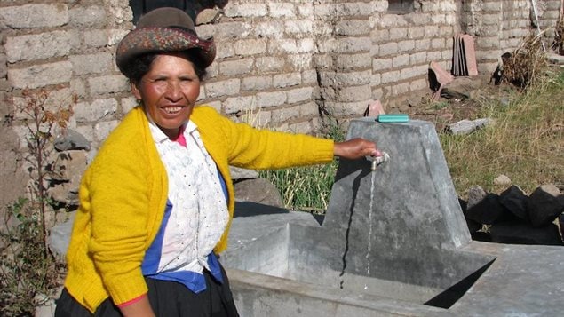 Hilfa, membre du comité d'eau potable, devant un lavadero en ciment construit pour chacune des familles de Cuchoquesera au Pérou