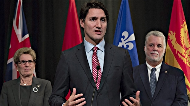 Le premier ministre canadien Justin Trudeau au centre et la première ministre provinciale de l'Ontario, Kathleen Wynne,  à sa gauche, et Philippe Couillard à sa droite qui est le premier ministre du Québec.