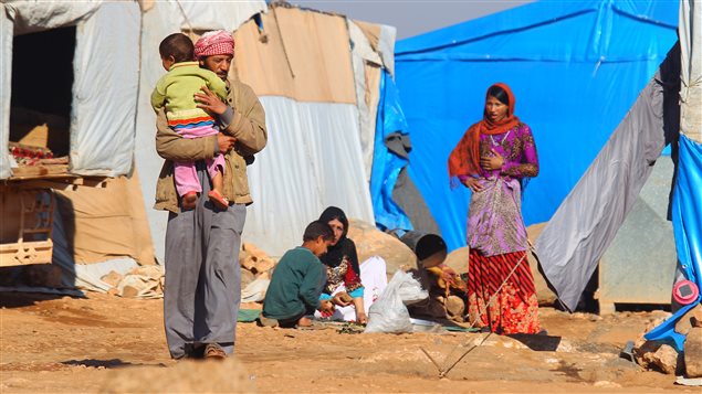  Internally displaced Syrians stand outside tents at a makeshift refugee camp in Sinjar town, in Idlib province, Syria November 20, 2015. 