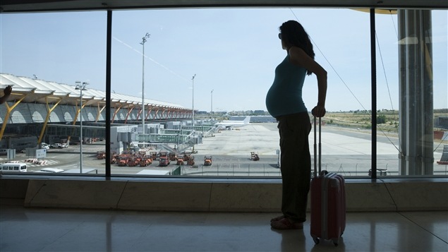 Une femme enceinte s'apprête à prendre un vol. Une femme enceinte s'apprête à prendre un vol.