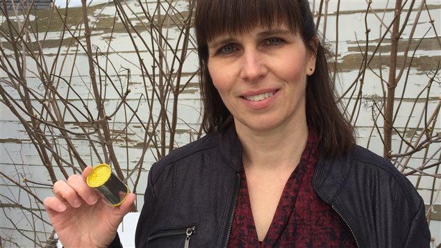 Janice Martel showing relative size of a McIntyre Powder canister full of microscopic grains of metallic powder. A small item with potentially huge health implications worldwide.