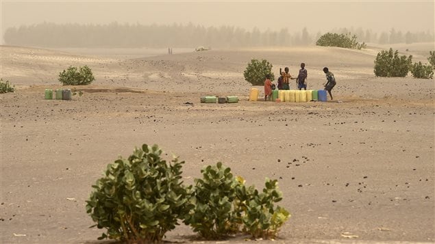 Des enfants puisent de l'eau d'un puits sur le site du lac asséché de Faguibine, près de Tombouctou, en Afrique. Des enfants puisent de l'eau d'un puits sur le site du lac asséché de Faguibine, près de Tombouctou, en Afrique.