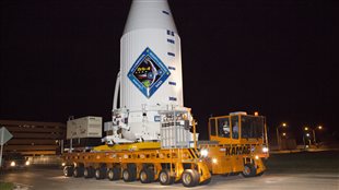  A transporter moves Orbital ATK's enhanced Cygnus spacecraft, fitted inside the payload fairing of a United Launch Alliance Atlas V, from the Payload Hazardous Servicing Facility at NASA's Kennedy Space Center in Florida to Space Launch Complex 41. The Cygnus is a cargo-only spacecraft that will take about 7,300 pounds of experiments, equipment and supplies to the International Space Station.