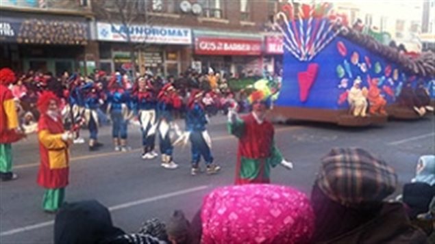 A clown gestures to onlookers on Bloor Street West near Bathurst Street at Toronto's 106th annual Santa Claus Parade. 