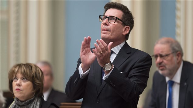 Quebec Interim Public Security Minister Pierre Moreau applauds people who were involved in the Polythecnique shooting as he introduces them, before tabling legislation creating a gun registry, during question period Thursday, December 3, 2015 at the legislature in Quebec City.