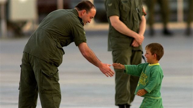 Un petit garçon kosovar serre la main d'un soldat canadien en 1999 Un petit garçon kosovar serre la main d'un soldat canadien en 1999