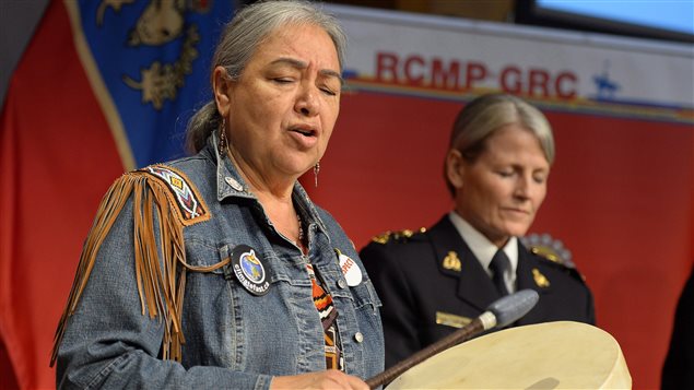  Elder Barbara Hill drums before the release of the RCMP Missing and Murdered Aboriginal Women: 2015 Update to the National Operational Overview Report, as Deputy Commissioner Janice Armstrong stands behind, in Ottawa on Friday, June 19, 2015. 