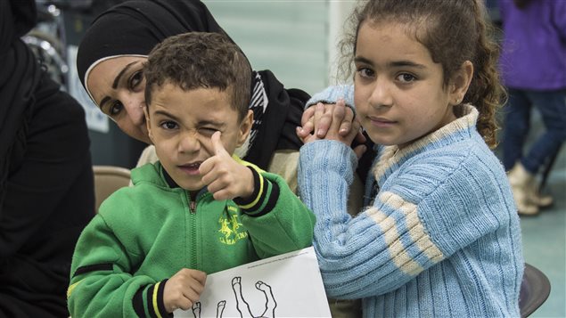  Two Syrian refugee children pose while their family undergoes medical screening before the beginning of an airlift to Canada, in Beirut, Lebanon December 9, 2015. 