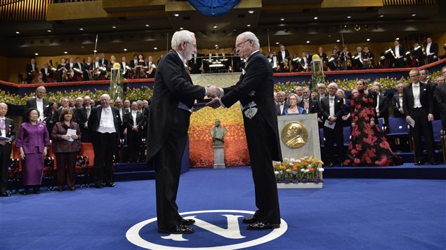 Arthur McDonald reçoit son prix Nobel des mains du roi de la Suède, Karl Gustaf. 